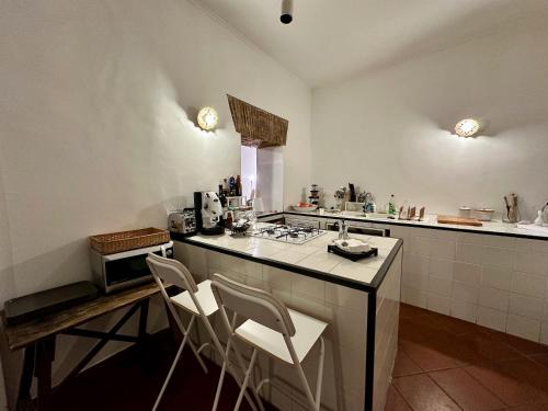 una cucina con un bancone e alcune sedie di Passepartout a Napoli