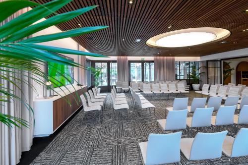 a conference room with white chairs and a plant at Servotel Saint-Vincent in Nice