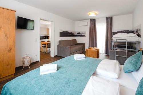 a bedroom with a large bed with a blue blanket at Hotel & Appartements Nice Garni in Ichenhausen