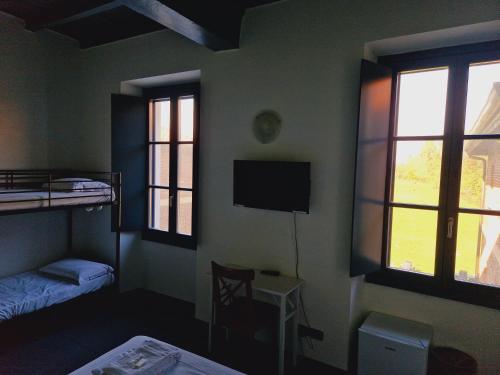 a room with two bunk beds and a television at B&B e Ostello, Parco di Monza, CASCINA COSTA ALTA in Monza