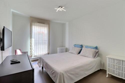 une chambre blanche avec un lit et un bureau dans l'établissement The Summer Break - 350m Beach - Free Parking, à La Ciotat