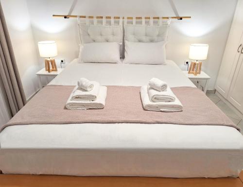 une chambre avec un lit blanc avec des serviettes dessus dans l'établissement Sunshine apartment, à Adamas