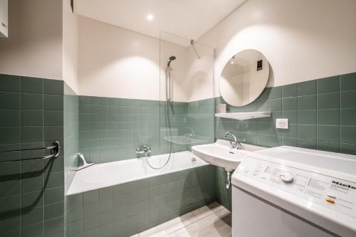une salle de bain avec une baignoire, un lavabo et une douche dans l'établissement CHEVRULS A5: Appartement central avec deux chambres, à Morzine