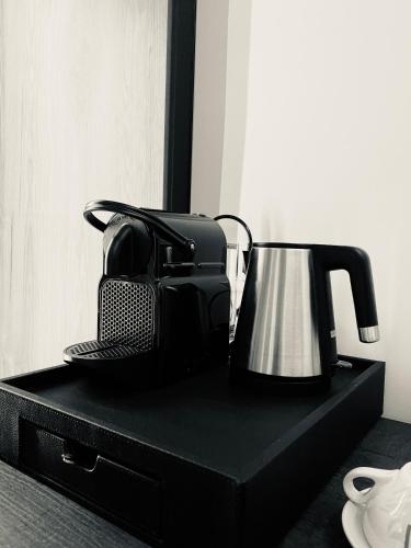 a tea kettle sitting on top of a black box at Tirana Central Rooms Blloku in Tirana