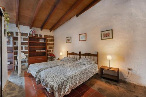 a bedroom with a bed and a table with two lamps at Casa Rural La Cuadra in Hermigua