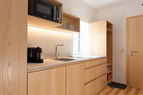 a kitchen with a sink and a microwave at Forsthaus Apartments - Die Ruheoase nahe Klaffer in Klaffer am Hochficht