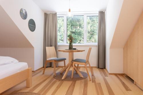 a bedroom with a table and two chairs and a bed at Forsthaus Apartments - Die Ruheoase nahe Klaffer in Klaffer am Hochficht