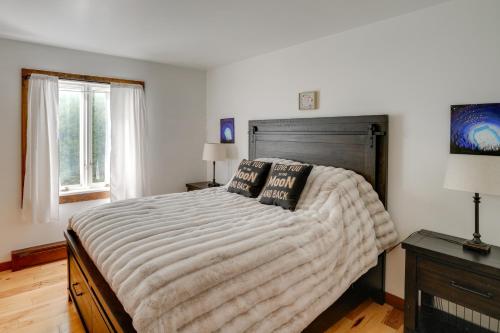 a bedroom with a large bed and two windows at 3 Mi to Colgate Lake Mtn-View Home, Deck and Grill! in East Jewett