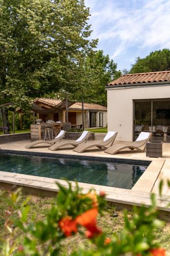 - une piscine avec des chaises longues à côté d'une maison dans l'établissement Gîtes Lou Hamou, à Vagnas