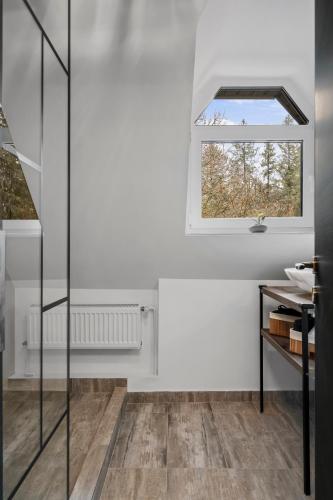 a bathroom with white walls and a window at SEVEN Apartments in Predeal