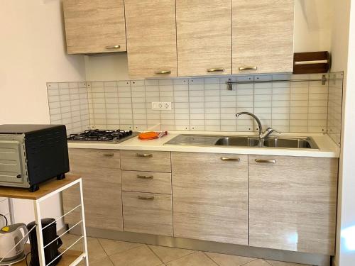 a kitchen with wooden cabinets and a sink at Gli ulivi della Monda in Finale Ligure