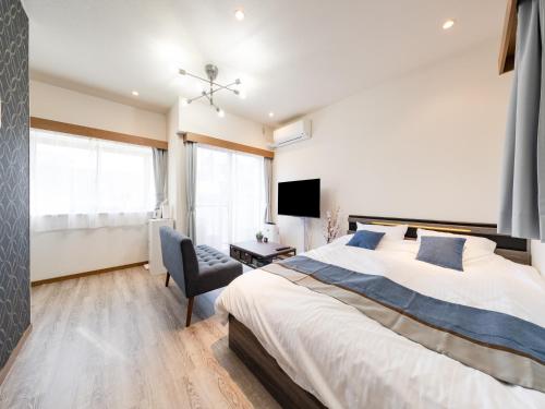 a bedroom with a large bed and a chair at Harajuku 3min, Omotesando 8min walk, Shibuya Area, Switch,Free Wi-Fi, PocketWi-Fi in Tokyo