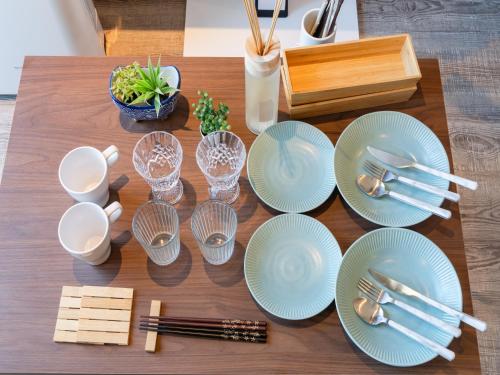 a table with blue plates and silverware on it at Harajuku 3min, Omotesando 8min walk, Shibuya Area, Switch,Free Wi-Fi, PocketWi-Fi in Tokyo