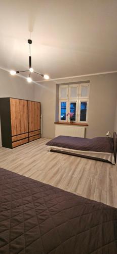 a bedroom with a bed and two windows at Apartament Starówka in Konin