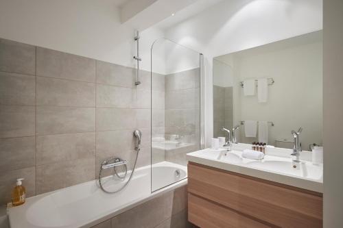 La salle de bains est pourvue d'une baignoire, de 2 lavabos et d'une douche. dans l'établissement Cannes Center, Nice 110m2, 3BR & 3BTH, Terrace, à Cannes