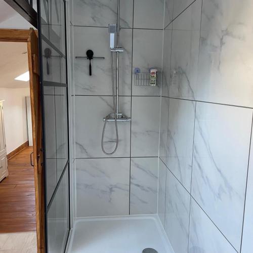 La salle de bains est pourvue d'une douche et de carrelage en marbre blanc. dans l'établissement 1712Villacarre'Villa-LeDorat, au Dorat