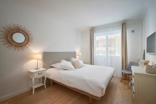une chambre blanche avec un lit et un miroir dans l'établissement Cannes Center, Nice 110m2, 3BR & 3BTH, Terrace, à Cannes