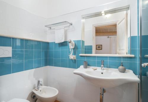 a blue and white bathroom with a sink and a toilet at Bosa Queen House in Bosa
