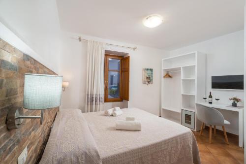 a small bedroom with a bed and a desk at Bosa Queen House in Bosa