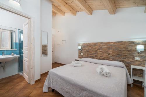 a bedroom with a bed with two towels on it at Bosa Queen House in Bosa
