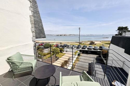 a balcony with chairs and a view of the ocean at Villa d’architecte contemporaine - Vue mer 180 in Larmor-Plage