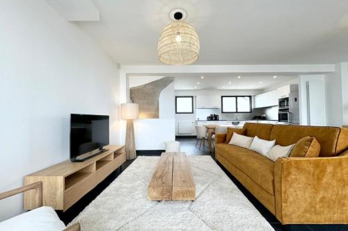 un salon avec un canapé et une table dans l'établissement Villa d’architecte contemporaine - Vue mer 180, à Larmor-Plage