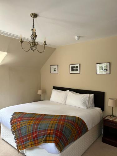 a bedroom with a bed with a colorful blanket on it at Estate Of Ord in Muir of Ord