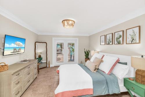 a bedroom with a bed and a dresser and a mirror at Dreamers Hideaway I Waterfront I Direct Access in Naples