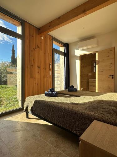 deux lits dans une chambre avec une grande fenêtre dans l'établissement Gîtes Lou Hamou, à Vagnas