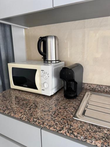 a microwave sitting on top of a kitchen counter at Porto Smart Apartments- airport in Perafita