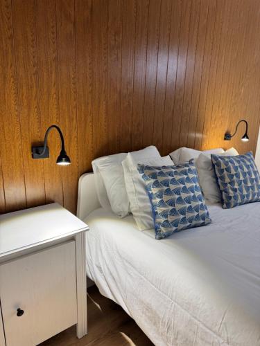 a bed with two blue and white pillows on it at Porto Smart Apartments- airport in Perafita