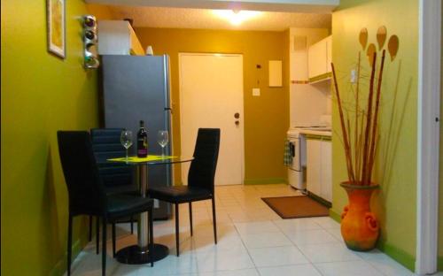a dining room with a table and chairs and a kitchen at Hylton New Kingston 21 in New Kingston