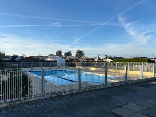 une piscine entourée d'une clôture dans l'établissement Mobil home dans Parc Résidentiel de Loisirs, à Hauteville-sur-Mer