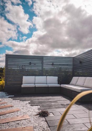 a patio with two white couches on a brick wall at The Hideaway Retreat in Omagh