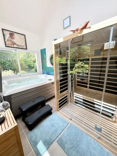 Cette chambre dispose d'un bain à remous et d'une fenêtre. dans l'établissement Villa de standing - Pleine nature - Jacuzzi, à Guidel