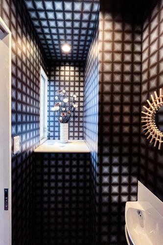 a bathroom with a sink and a vase of flowers at AnsouHouseメゾネット 大阪ドーム in Osaka