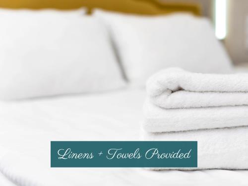 a pile of towels sitting on top of a bed at Cherry Street Loft (B) Pet-Friendly & In the Heart of Downtown Black Mtn! in Black Mountain