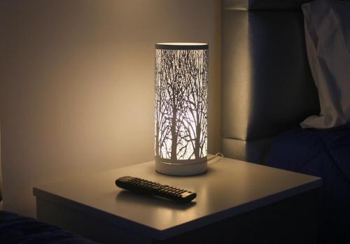 a lamp sitting on a table with a remote control at AM Residence in Braga