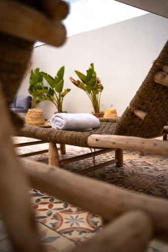 a room with a table with wicker chairs and plants at Med Stay Apartment with amazing Terrace - A2 in Tamraght Ouzdar