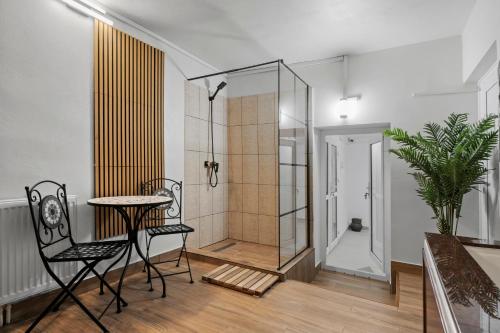 a bathroom with a shower and a table and chairs at SEVEN Apartments in Predeal