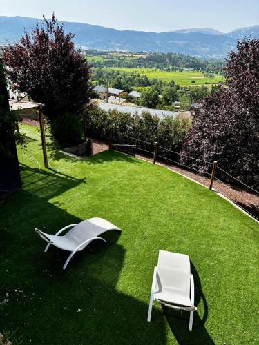two white chairs on a lawn with a view at Valley Balcony in Enveitg