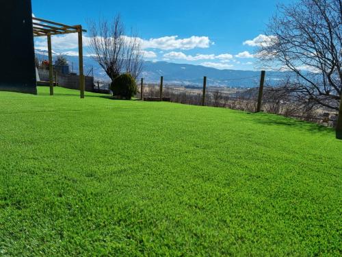 a field of green grass with a fence at Valley Balcony in Enveitg
