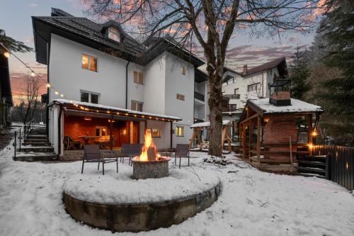 a house with a fire pit in the snow at SEVEN Apartments in Predeal
