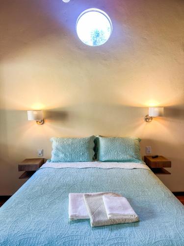 a bedroom with a bed with two towels on it at Pousada da Fonte in Lençóis