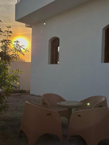 une table et des chaises devant un mur blanc dans l'établissement Ashry, à Al Aqālitah