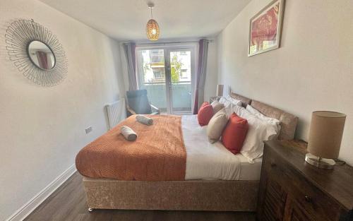 a bedroom with a large bed with red pillows at Apartment in Ashford near outlets and Ashford International Station in Willesborough