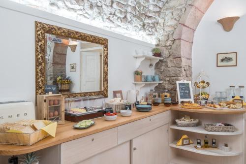 a room with a counter with food and a mirror at Bosa Queen House in Bosa