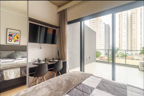 a bedroom with a bed and a table with chairs at Studio On Alvorada Garden 204 - Vila Olímpia in Sao Paulo