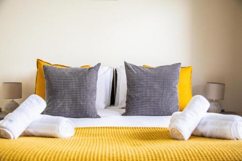 a bed with white towels and pillows on it at Lovely Views 2 Bedroom central apartment in Ashford in Ashford