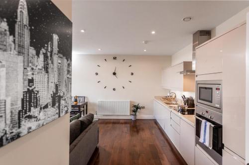 a kitchen with a large clock on the wall at Lovely Skyline Views 2 Bedroom Apartment in Ashford in Ashford